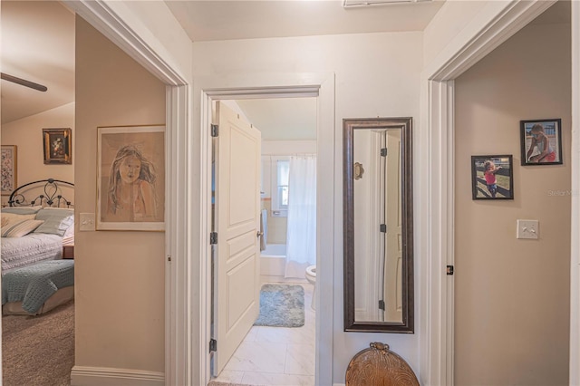 hallway with light carpet and vaulted ceiling