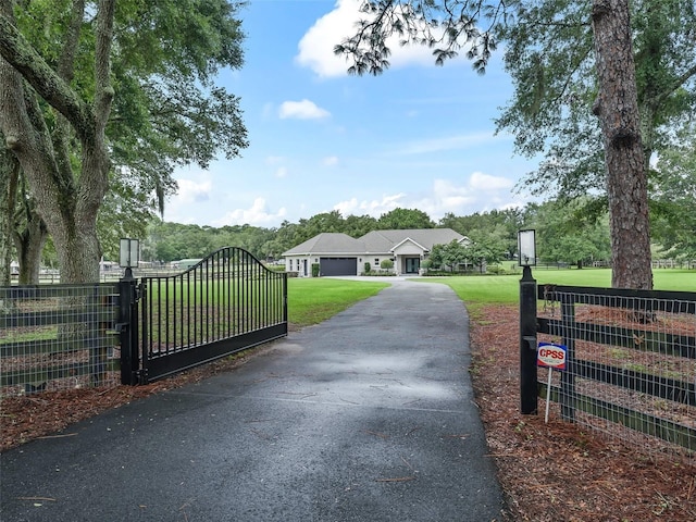 view of gate with a yard and fence