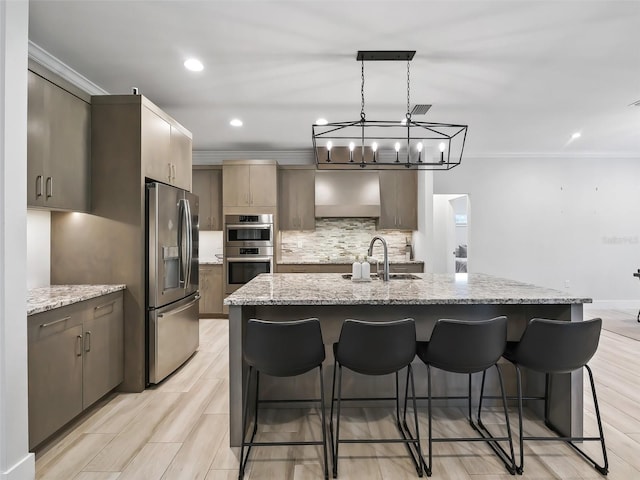 kitchen with a sink, appliances with stainless steel finishes, crown molding, a kitchen breakfast bar, and backsplash