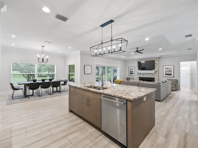 kitchen with visible vents, ceiling fan with notable chandelier, a sink, a fireplace, and dishwasher