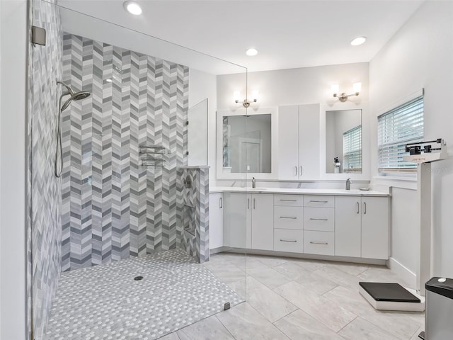 bathroom with a sink, recessed lighting, double vanity, and a tile shower