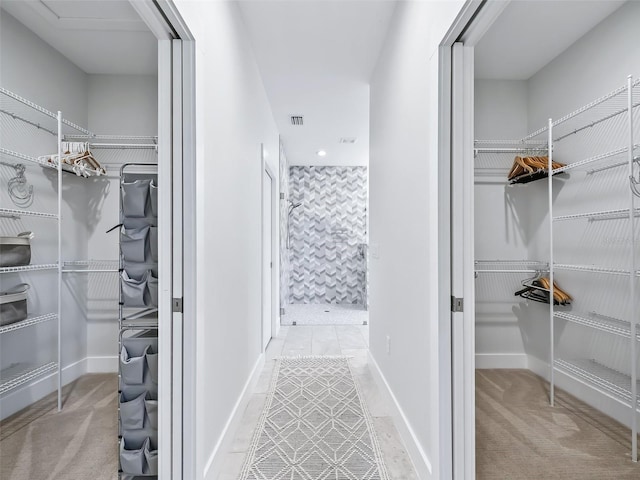 full bath featuring visible vents, baseboards, a walk in closet, and a stall shower
