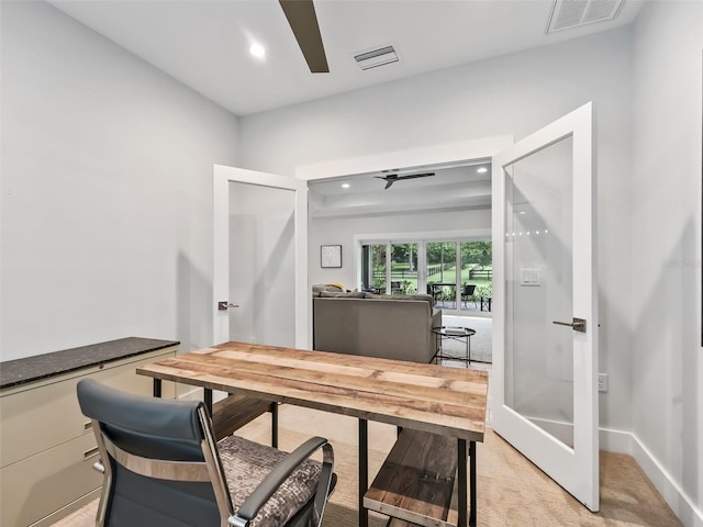 office area with light carpet, visible vents, and ceiling fan