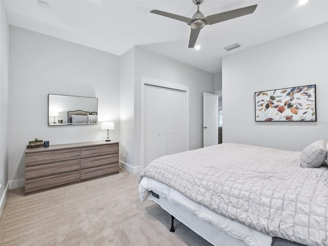 bedroom with visible vents, light carpet, a ceiling fan, a closet, and baseboards