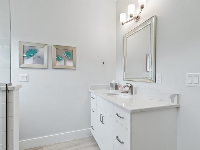 bathroom featuring vanity, baseboards, and wood finished floors