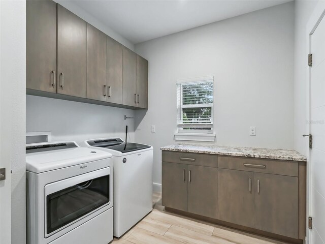 washroom with light hardwood / wood-style flooring, cabinets, and independent washer and dryer