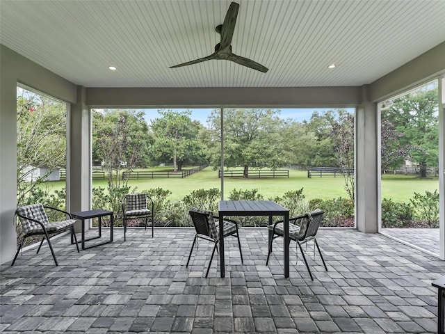 sunroom with outdoor dining space and ceiling fan