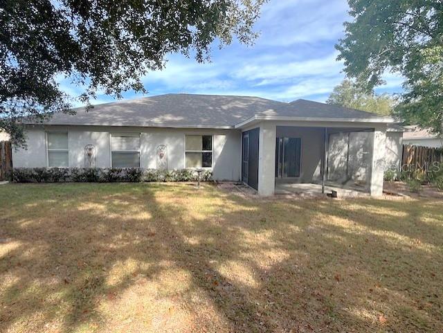 back of property featuring a sunroom and a yard