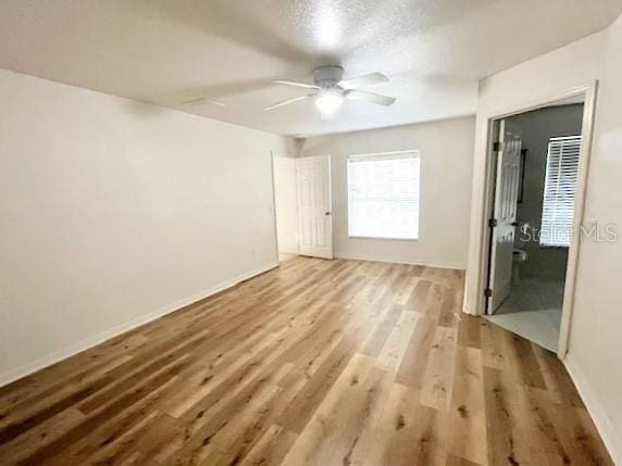 unfurnished room with hardwood / wood-style floors, ceiling fan, and a textured ceiling