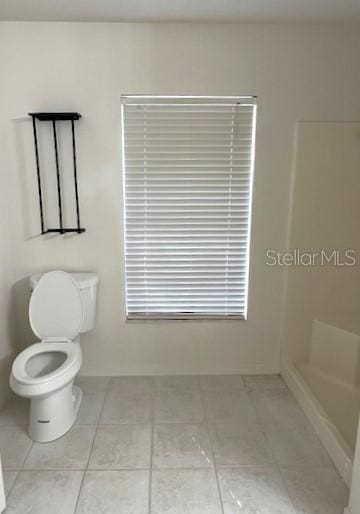 bathroom featuring tile patterned flooring, toilet, and walk in shower