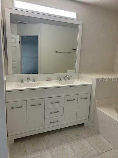 bathroom with tile patterned floors, a bathtub, and vanity