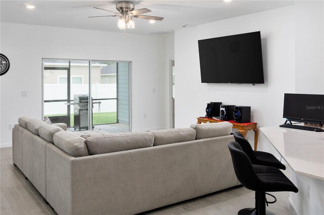 living room featuring light hardwood / wood-style floors and ceiling fan