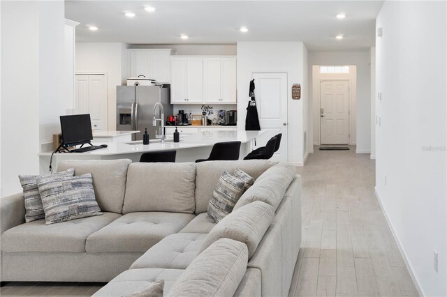 living room with sink and light wood-type flooring