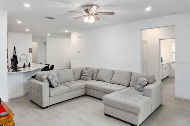 living room featuring light wood-type flooring and ceiling fan