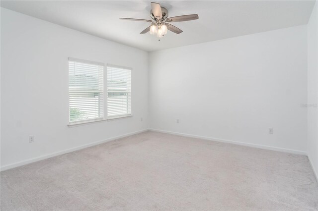 spare room featuring light carpet and ceiling fan