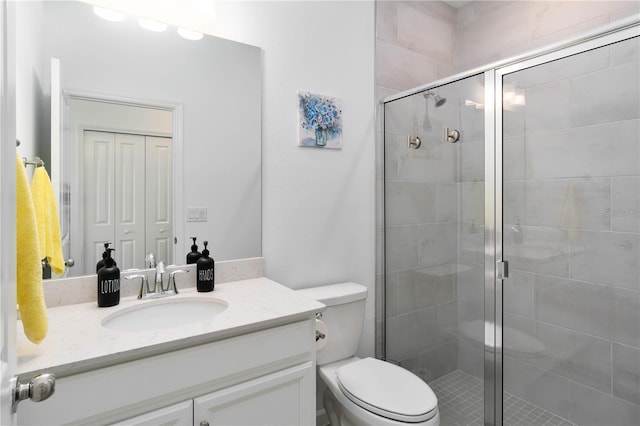 bathroom with vanity, toilet, and a shower with shower door