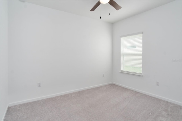 spare room with ceiling fan and light colored carpet