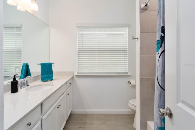 bathroom with vanity, toilet, and a tile shower