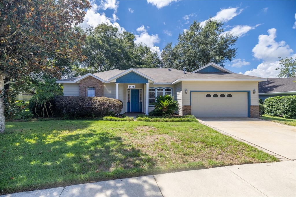 single story home featuring a front lawn and a garage