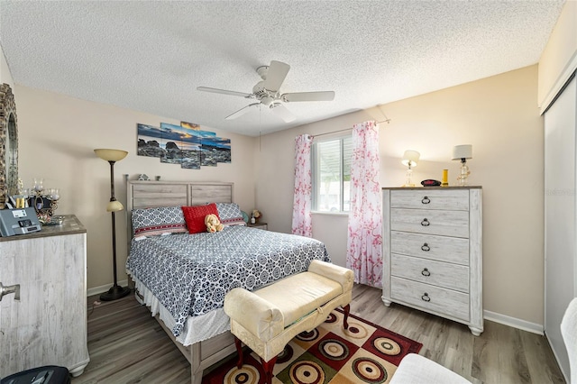 bedroom featuring a closet, wood-type flooring, a textured ceiling, and ceiling fan