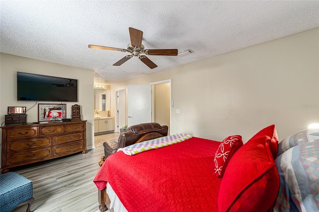 bedroom featuring a textured ceiling, ceiling fan, connected bathroom, and light hardwood / wood-style floors