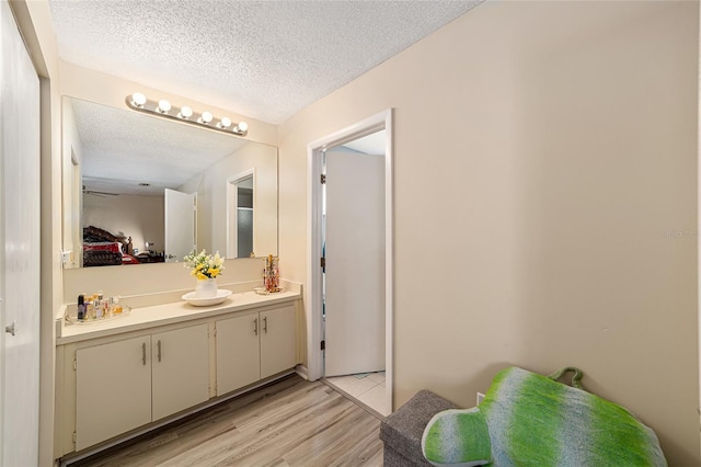 bathroom with hardwood / wood-style floors, a textured ceiling, and vanity