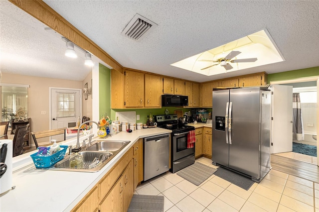 kitchen featuring a wealth of natural light, stainless steel appliances, ceiling fan, and a textured ceiling