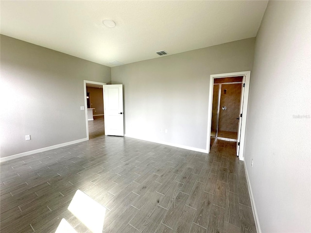 unfurnished room with wood finished floors, visible vents, and baseboards