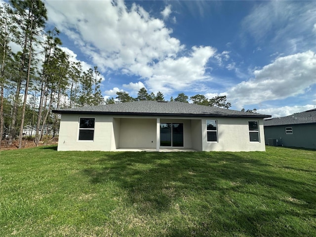 back of property with central air condition unit, a patio area, a yard, and stucco siding