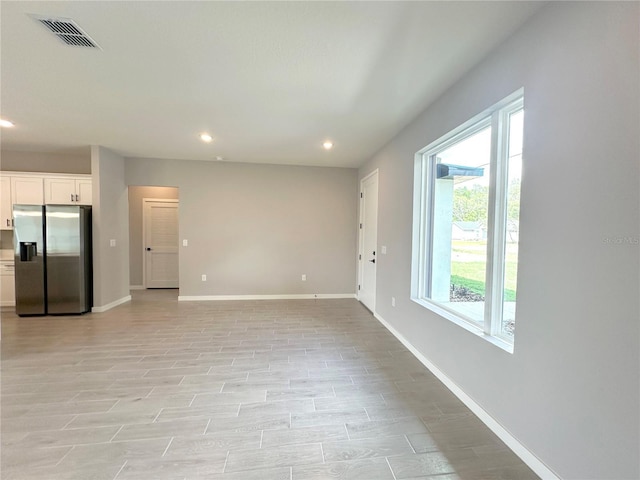 unfurnished living room with recessed lighting, light wood-type flooring, visible vents, and baseboards