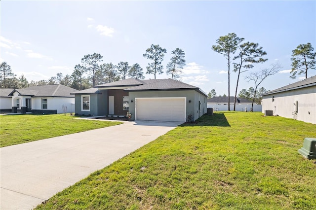 ranch-style home featuring concrete driveway, central AC unit, an attached garage, and a front yard