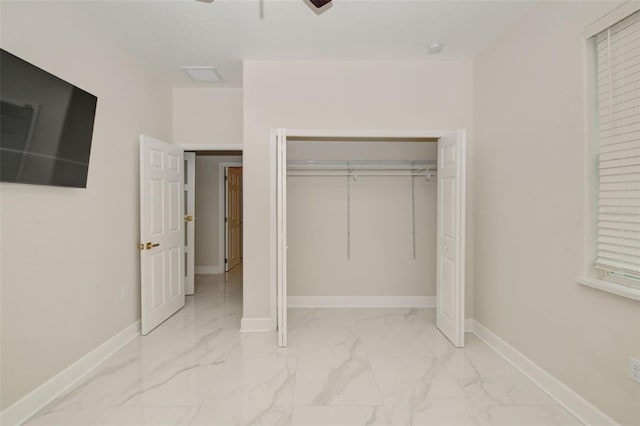 unfurnished bedroom with ceiling fan and a closet