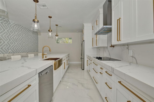 kitchen with pendant lighting, light stone counters, sink, wall chimney range hood, and stainless steel appliances