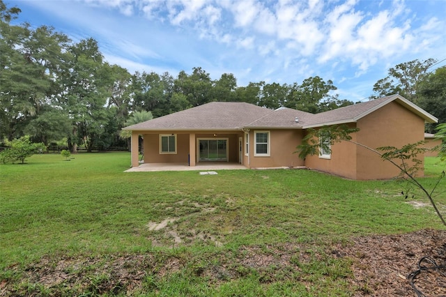 rear view of property featuring a yard and a patio area