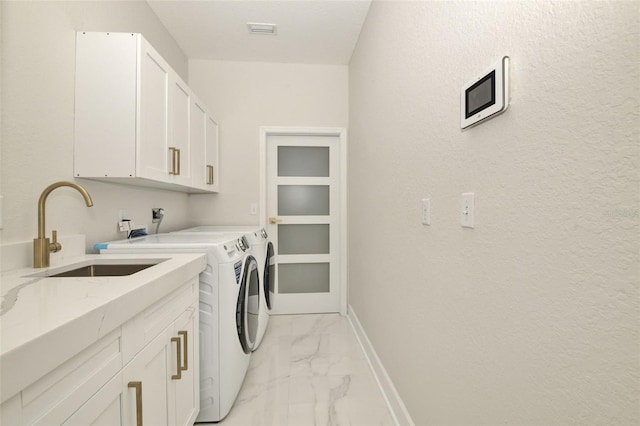 clothes washing area with cabinets, sink, and independent washer and dryer