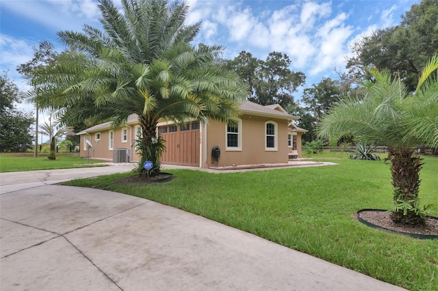 view of side of property with a lawn and central AC