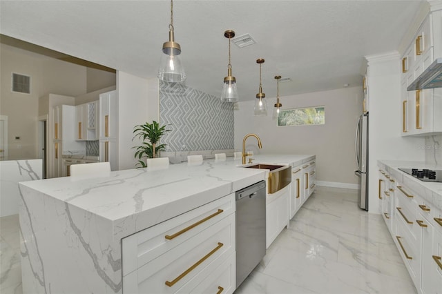 kitchen with light stone counters, hanging light fixtures, sink, a large island, and stainless steel appliances