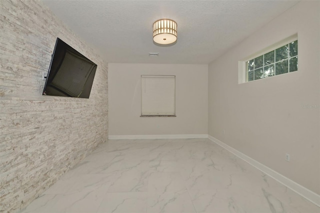 unfurnished room with a textured ceiling