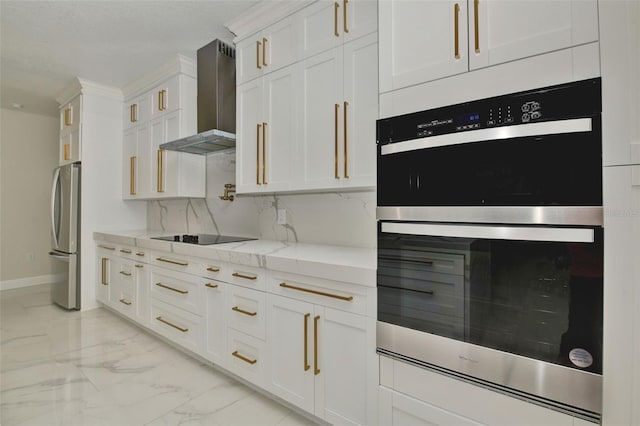 kitchen featuring appliances with stainless steel finishes, tasteful backsplash, white cabinets, light stone countertops, and wall chimney range hood