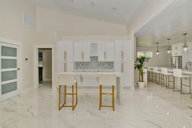 kitchen featuring a breakfast bar, a center island, stainless steel fridge with ice dispenser, and white cabinets