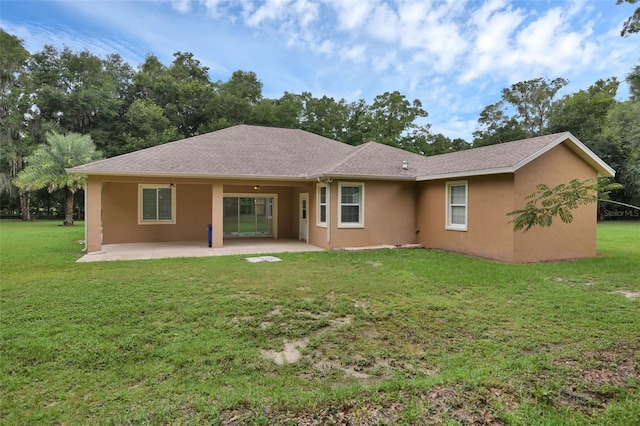 rear view of house with a yard and a patio