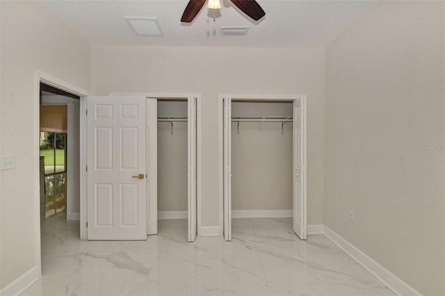 unfurnished bedroom with ceiling fan and multiple closets