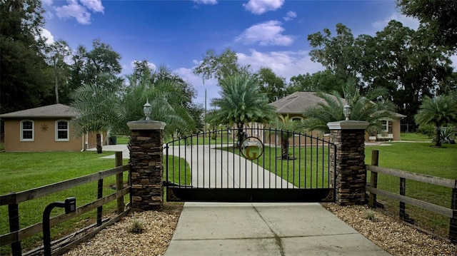 view of gate with a lawn