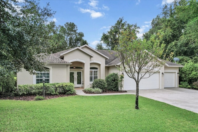 ranch-style house with a front yard, french doors, and a garage