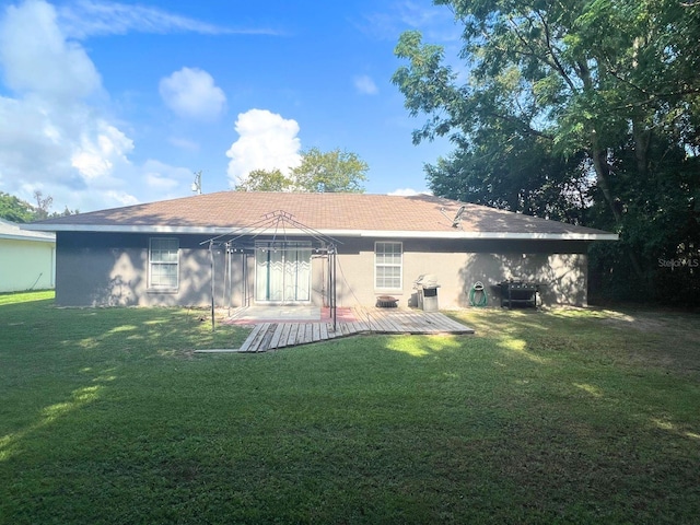 rear view of property featuring a lawn and a gazebo