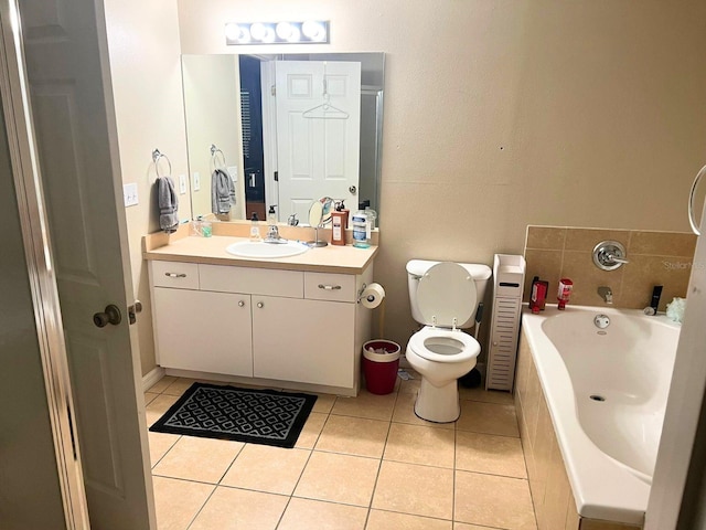 bathroom with tile patterned floors, vanity, toilet, and tiled tub