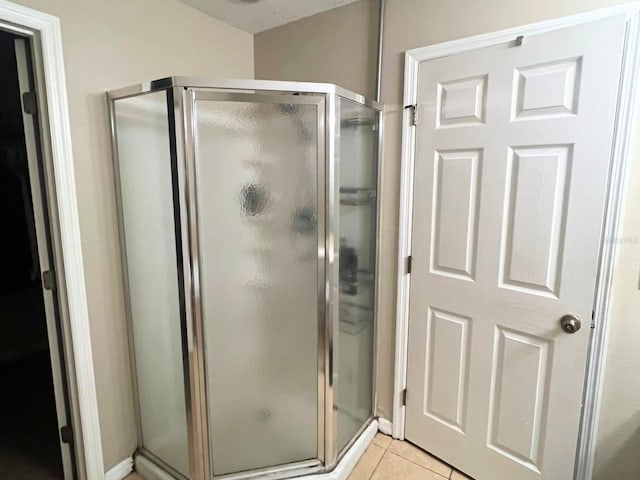 bathroom featuring tile patterned flooring and an enclosed shower