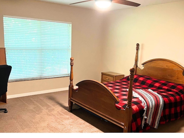 bedroom featuring ceiling fan, dark carpet, and multiple windows