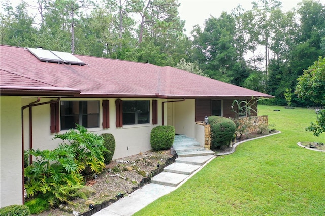 21389 SW 102nd Street Rd, Dunnellon, FL 34431 - ranch-style home featuring solar panels, a front yard, stucco siding, and a shingled roof