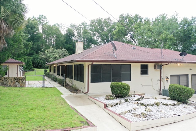 view of front of house with cooling unit and a front lawn